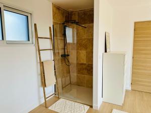 a shower with a glass door in a bathroom at Maison neuve proche des plages in Plouarzel