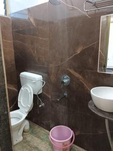 a bathroom with a toilet and a sink at Hotal Arvind in Patna