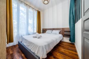 Un dormitorio con una cama con dos almohadas encima. en Le Parmentier - RER C à 5min, Self-Checkin, en Vitry-sur-Seine