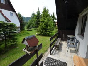 a balcony with a grill and a table and chairs at Holiday Home near Klínovec Ski Lift in Loučná pod Klínovcem