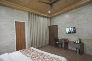 a bedroom with a bed and a desk and a television at Hotel Address Inn in Noida