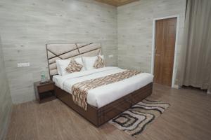 a bedroom with a large bed and a wooden door at Hotel Address Inn in Noida