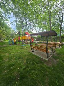 a park with two benches and a playground at Yassen Holiday Village in Sunny Beach