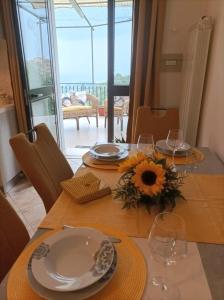 a table with plates and glasses and a sunflower on it at Casa Vacanze Nausicaa in Tiriolo
