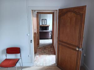 a room with a door and a chair and a kitchen at Gisors centre in Gisors