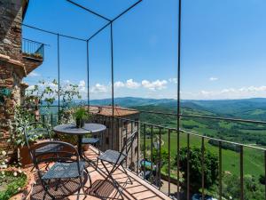 a balcony with a table and chairs and a view at Tuscan Hilltop Getaway in Montecastelli Pisano