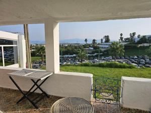 Un porche con una mesa y vista a un estacionamiento. en Nassime 1, en Cabo Negro
