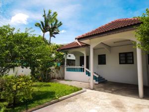 a small white house with a palm tree at Cozy House 2BR BTS Ekkamai in Bangkok