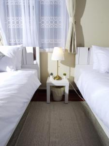 two beds sitting next to each other in a bedroom at Cozy House 2BR BTS Ekkamai in Bangkok