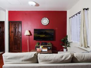a living room with a couch and a red wall at Cozy House 2BR BTS Ekkamai in Bangkok