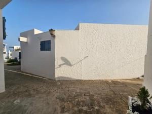 Un edificio blanco con una puerta al costado. en Nassime 1, en Cabo Negro 21 fotos más