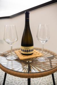 a bottle of wine sitting on a table with two wine glasses at Panormos91 Rooms&Terrace in Palermo +12 photos