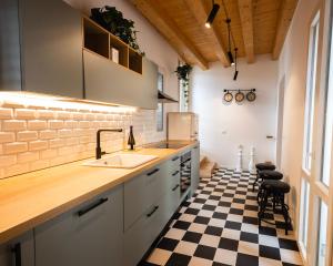 a kitchen with a sink and a black and white checkered floor at Panormos91 Rooms&Terrace in Palermo