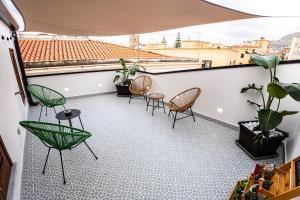 a balcony with chairs and potted plants at Panormos91 Rooms&Terrace in Palermo