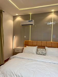 a bedroom with a large bed with white sheets at Pentagon by Riz Royalty Homes in Magodo