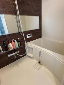 ein Badezimmer mit Badewanne und Spiegel in der Unterkunft Cozy corner in Tokio + 6 Fotos