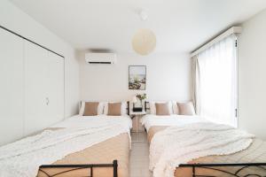 twee bedden in een slaapkamer met witte muren bij Brand New Luxury Suite 7 min to Omotesando 2 min to Shibuya in Tokyo