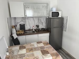 a small kitchen with a refrigerator and a microwave at Alföldi-kuckó in Makó