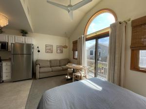a bedroom with a bed and a kitchen with a window at 38 Piece Of Heaven Condo in Hatteras