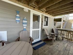 a porch of a house with a table and chairs at 38 Piece Of Heaven Condo in Hatteras