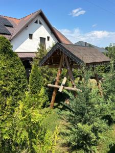 a house with a roof on top of some trees at Casa Berbec in Dealul Viei
