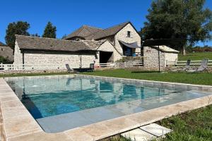 a swimming pool in front of a house at Banassac Canilhac Gite pour 4 personnes avec piscine partagée et vue panoramique en Lozère in Banassac