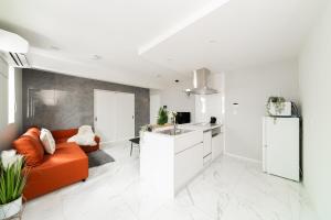 een woonkamer met een oranje bank en een keuken bij Brand New Luxury Suite 7 min to Omotesando 2 min to Shibuya in Tokyo
