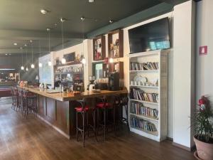 Eine Küche mit einer Bar mit Hockern und einem Bücherregal in der Unterkunft Jubilee Hotel Troodos in Troodos