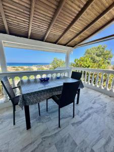 a table and chairs on a balcony with a view of the ocean at Ikidiki Beach Villa in Ierissos