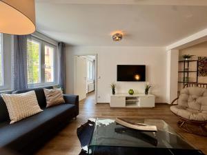 a living room with a couch and a tv at Corner Loft - Altstadt Design Apartment in Freiburg im Breisgau