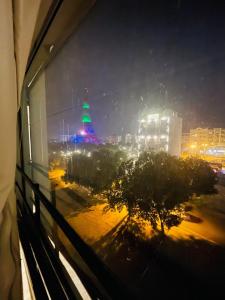 a view of a city at night from a window at Furnished Apparment Eiffel Tower Bahria town Lahore in Dargai