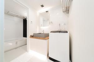 een witte badkamer met een wastafel en een spiegel bij Brand New Luxury Suite 7 min to Omotesando 2 min to Shibuya in Tokyo