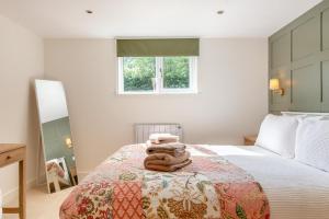 Un dormitorio con una cama con toallas. en Bluebell Farm - The Cabin, en Shurdington 17 fotos más