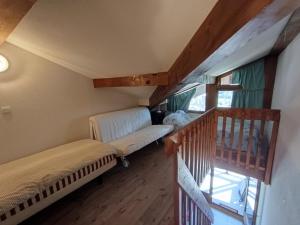 ein Dachzimmer mit Couch und Treppe in der Unterkunft Duplex 4 pers. au calme avec parking, vue imprenable - FR-1-445-227 in Montgenèvre