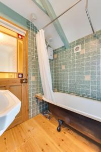 une salle de bain avec une baignoire et un lavabo dans l'établissement Crown Mine Cottage, à Saint Just