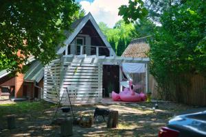 a small house with a porch and a pink object in front at Paulanyi's Island Heart of Woods, Szentendre Island in Szigetmonostor +10 photos