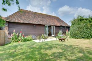 a house with a yard with a swing at Wagon Lodge at Forstal Farm in Tenterden