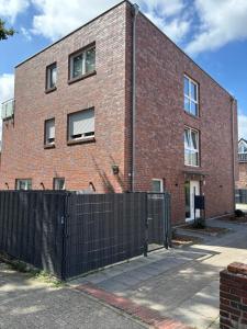 a brick building with a black fence in front of it at Home & Apart - Apartment mit Stil & Wohlfühlambiente in Oldenburg