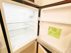 una nevera abierta con un cartel en la puerta en Nogata Relaxing Home D2, en Tokio
