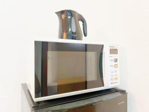 un microondas con un hervidor de agua encima en Nogata Relaxing Home D2, en Tokio