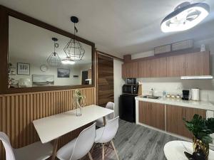 a kitchen with a table and white chairs in a room at MyOneSpace4u at One Spatial Condo Hotel in Iloilo City