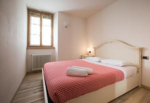 a bedroom with a bed with a red and white blanket at Casa del Sol Apartaments in Bormio
