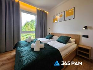 a bedroom with two beds and a large window at Apartament Wiatr od Morza w Let's Sea - BASEN, JACUZZI, SAUNA, SIŁOWNIA, STREFA CHILL, PARKING W CENIE - 365PAM in Gąski