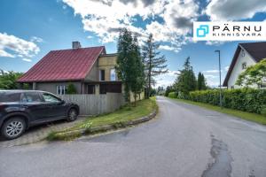 a car parked on the side of a road next to a house at Sireli Holiday Home in Pärnu