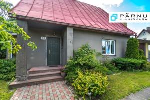 a small house with a green door and a red roof at Sireli Holiday Home in Pärnu +4 photos