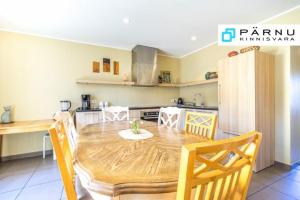 a kitchen with a wooden table and a dining room at Sireli Holiday Home in Pärnu