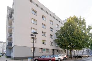 a white building with cars parked in front of it at Sosnowiec Victory Apartment by BookingHost in Sosnowiec