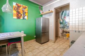 a kitchen with a refrigerator in a green wall at Sosnowiec Victory Apartment by BookingHost in Sosnowiec