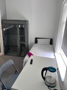 a small room with two beds and a table with a lamp at Triple room Private Bath Near LFC Free Street Parking No Breakfast in Liverpool +3 photos
