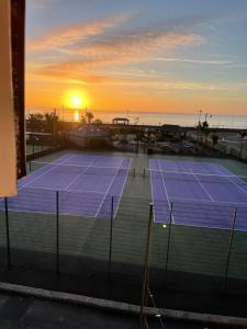 a tennis court with the sunset in the background at Bay view apartment in Penzance